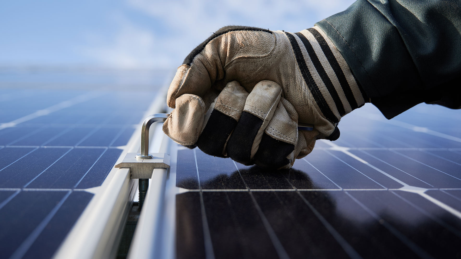 contractor hand close up with glove adjusting solar panel for installation ripon ca